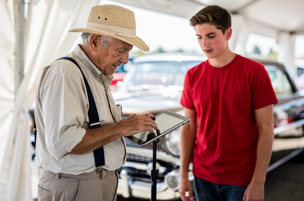 A spectator using the voting station tablet in the shade of the registration tent
